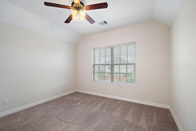 empty room with visible vents, carpet flooring, and lofted ceiling