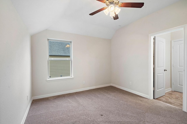interior space with carpet flooring, ceiling fan, baseboards, and lofted ceiling