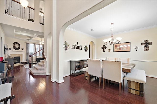 dining room with baseboards, arched walkways, a glass covered fireplace, and stairs