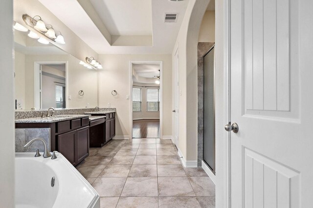 bathroom featuring visible vents, a bath, a sink, double vanity, and a shower stall