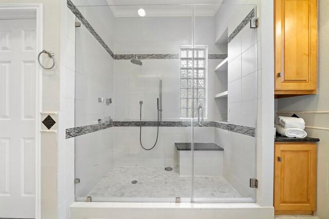 full bathroom with ornamental molding and a stall shower