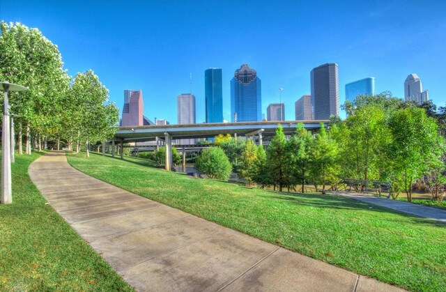 view of community with a lawn and a view of city