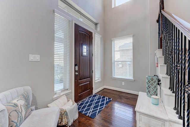entrance foyer featuring a wealth of natural light, baseboards, and dark wood finished floors
