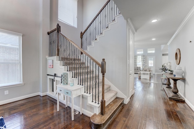 stairs featuring crown molding, wood-type flooring, baseboards, and recessed lighting