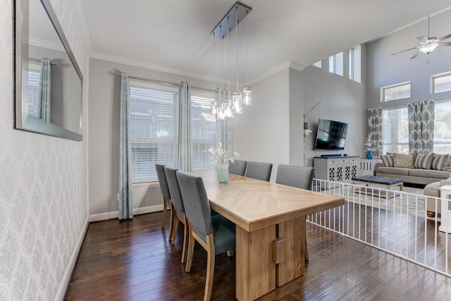 dining area with dark wood-style flooring, ornamental molding, baseboards, and ceiling fan with notable chandelier