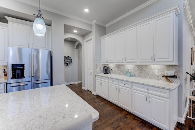 kitchen with tasteful backsplash, white cabinets, arched walkways, dark wood-style flooring, and high end fridge