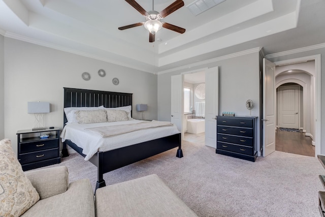carpeted bedroom featuring visible vents, a raised ceiling, arched walkways, a ceiling fan, and crown molding