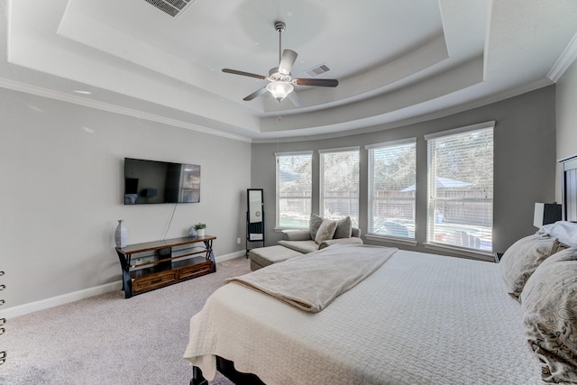 carpeted bedroom featuring visible vents, multiple windows, crown molding, and a raised ceiling