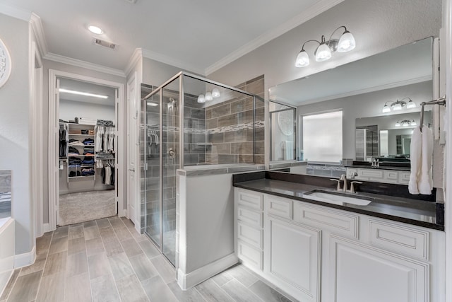 full bathroom featuring crown molding, a shower stall, vanity, a spacious closet, and visible vents