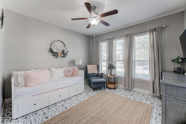 living area featuring a healthy amount of sunlight, baseboards, and a ceiling fan