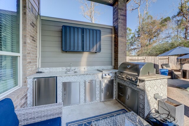 view of patio / terrace with grilling area, an outdoor kitchen, a sink, and fence