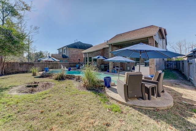 back of property featuring a fenced in pool, a patio, brick siding, a fenced backyard, and a lawn