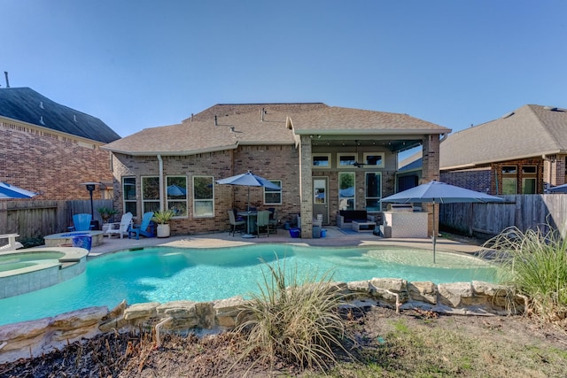 view of swimming pool featuring a patio area, a fenced backyard, and a pool with connected hot tub