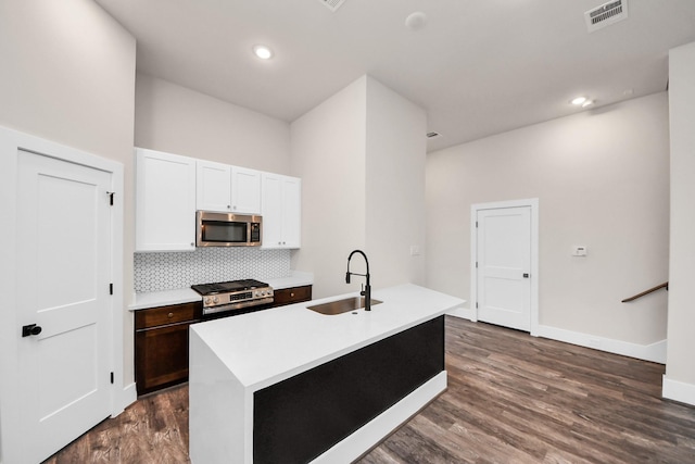 kitchen featuring white cabinets, a sink, dark wood-style flooring, visible vents, and appliances with stainless steel finishes