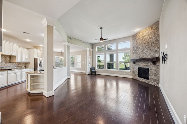 8227 Caroline Ridge Dr, Humble, TX 77396 - unfurnished living room with ornate columns, ceiling fan, baseboards, and plenty of natural light
