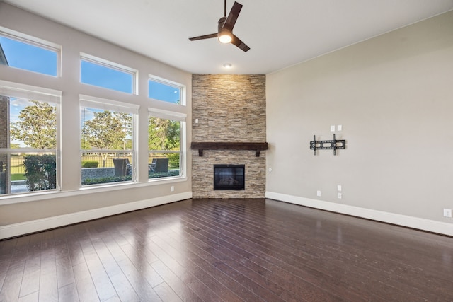 8227 Caroline Ridge Dr, Humble, TX 77396 - unfurnished living room with ceiling fan, baseboards, hardwood / wood-style flooring, and a stone fireplace