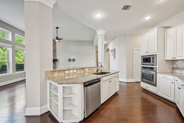 8227 Caroline Ridge Dr, Humble, TX 77396 - kitchen with appliances with stainless steel finishes, a sink, open shelves, dark wood-style floors, and tasteful backsplash
