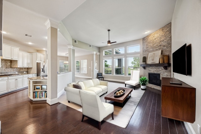 8227 Caroline Ridge Dr, Humble, TX 77396 - living area featuring ornate columns, ceiling fan, dark wood-style floors, plenty of natural light, and recessed lighting
