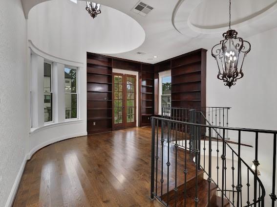 1408 W 23rd St, Houston, TX 77008 - entrance foyer featuring visible vents, baseboards, an inviting chandelier, a textured wall, and wood finished floors