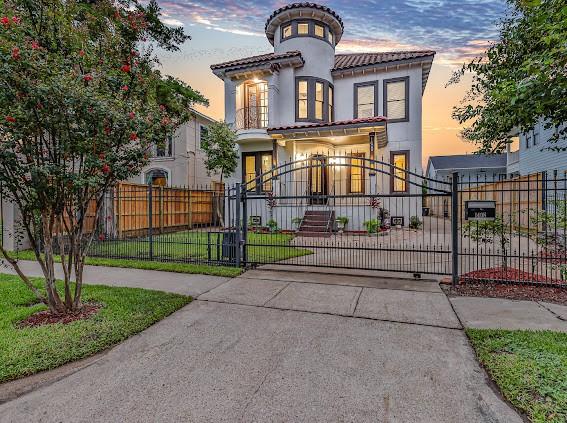 1408 W 23rd St, Houston, TX 77008 - mediterranean / spanish-style home with a tile roof, driveway, a gate, and a fenced front yard