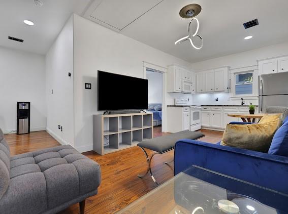 1408 W 23rd St, Houston, TX 77008 - living room with visible vents, baseboards, recessed lighting, and wood finished floors