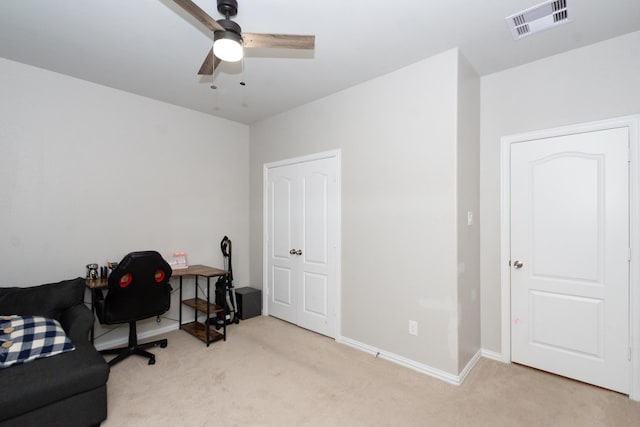 carpeted home office with a ceiling fan and baseboards