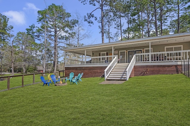 212 Woodcrest Dr, Brookeland, TX 75931 - rear view of house featuring an outdoor fire pit, stairway, and a lawn