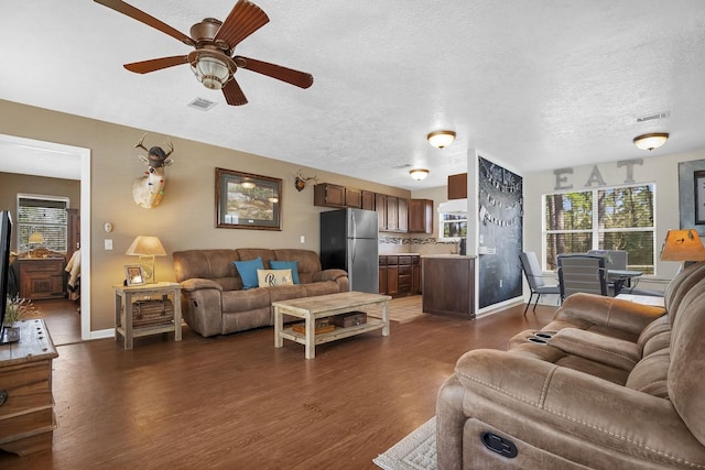 212 Woodcrest Dr, Brookeland, TX 75931 - living area featuring dark wood-style flooring, visible vents, ceiling fan, and baseboards