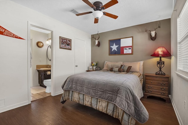 212 Woodcrest Dr, Brookeland, TX 75931 - bedroom featuring a textured ceiling, wood finished floors, ensuite bath, and visible vents