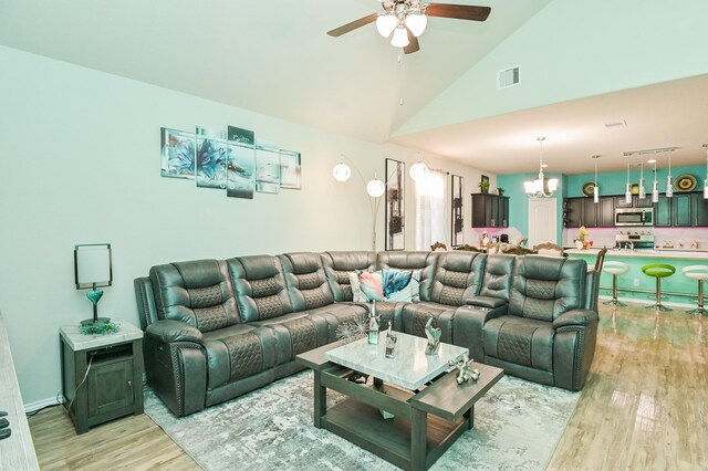 21003 Iris Holly St, Katy, TX 77449 - living room featuring light wood-type flooring, ceiling fan with notable chandelier, high vaulted ceiling, and visible vents
