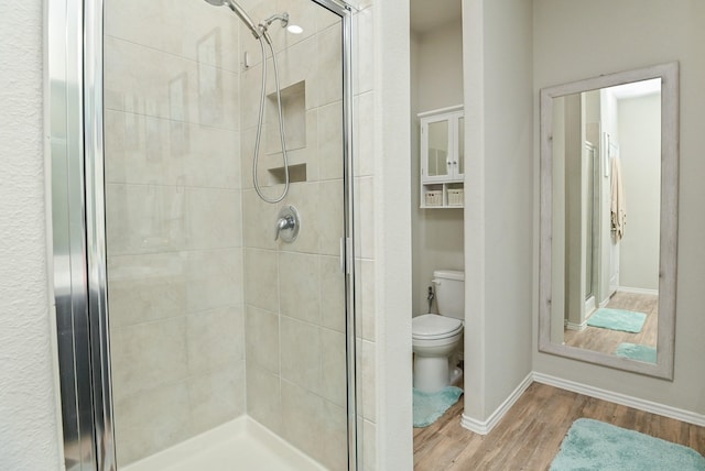 21003 Iris Holly St, Katy, TX 77449 - bathroom featuring toilet, baseboards, a stall shower, and wood finished floors