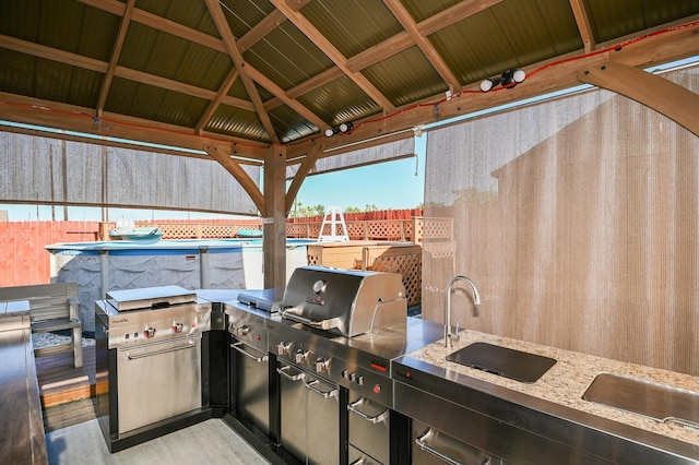 21003 Iris Holly St, Katy, TX 77449 - view of patio / terrace with area for grilling, an outdoor kitchen, fence, a gazebo, and a fenced in pool