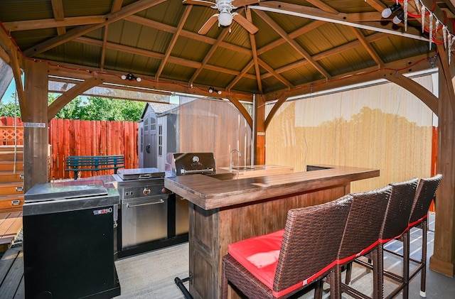 21003 Iris Holly St, Katy, TX 77449 - view of patio featuring a gazebo, outdoor wet bar, an outdoor structure, fence, and an outdoor kitchen
