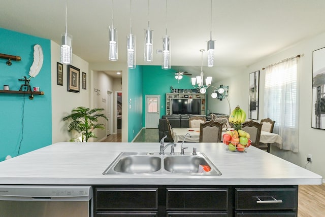 21003 Iris Holly St, Katy, TX 77449 - kitchen with dark cabinetry, dishwasher, light countertops, a sink, and open floor plan