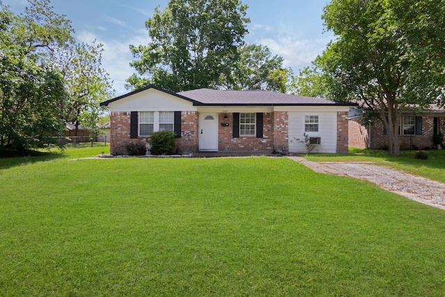 single story home featuring fence, a front yard, and brick siding