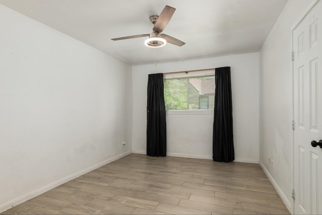 unfurnished room with ceiling fan, baseboards, and light wood-type flooring