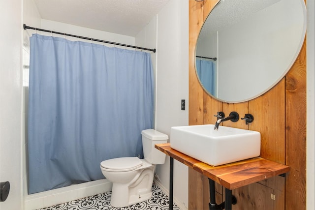 full bathroom featuring a sink, toilet, a shower with curtain, and baseboards
