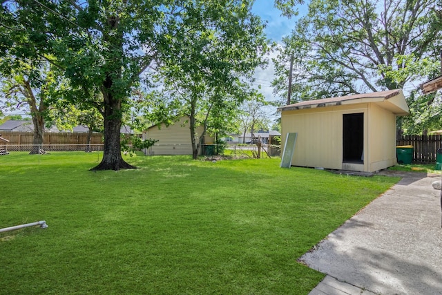 view of yard featuring an outdoor structure, a shed, and a fenced backyard