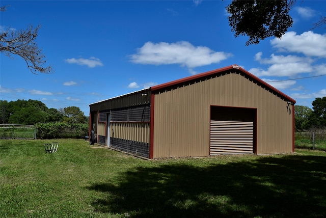 view of pole building featuring a lawn and fence