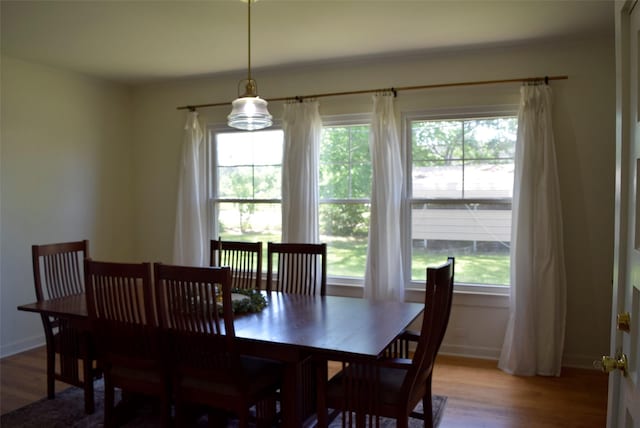 dining area featuring light wood finished floors and baseboards