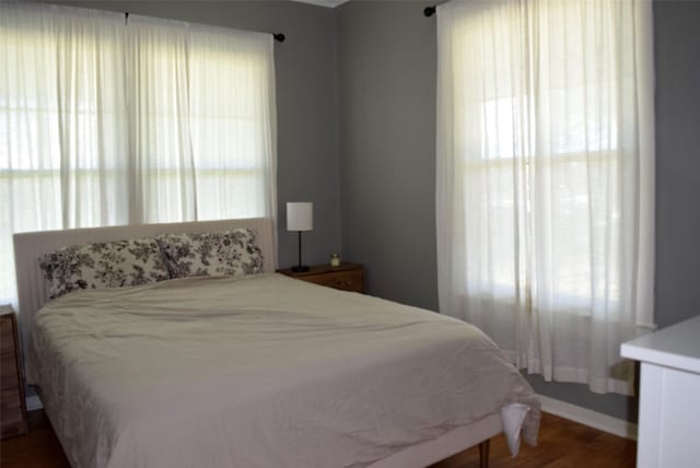 bedroom with baseboards and wood finished floors