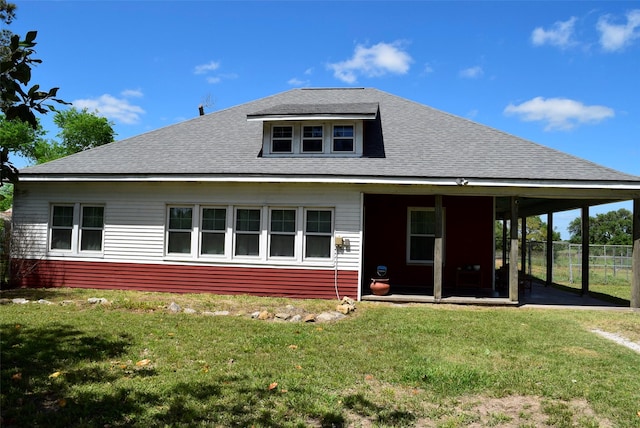 rear view of house featuring a yard, a sunroom, fence, and roof with shingles