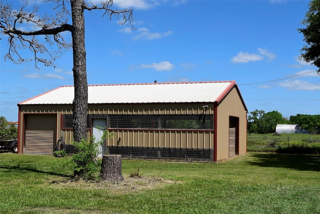 view of property exterior featuring a lawn, an outdoor structure, and metal roof