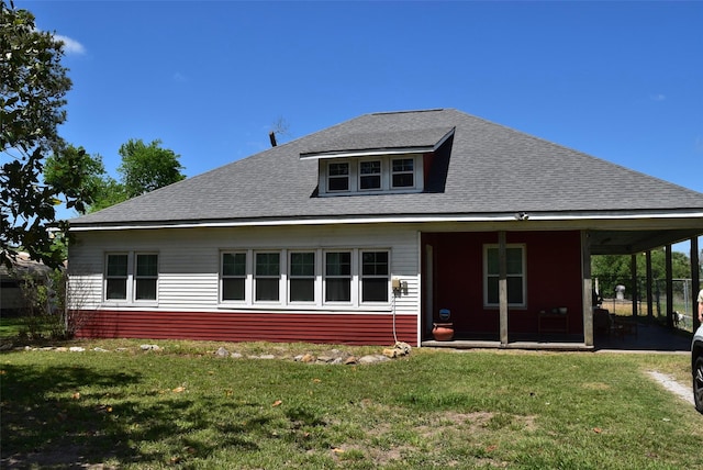 rear view of house featuring a yard and a shingled roof