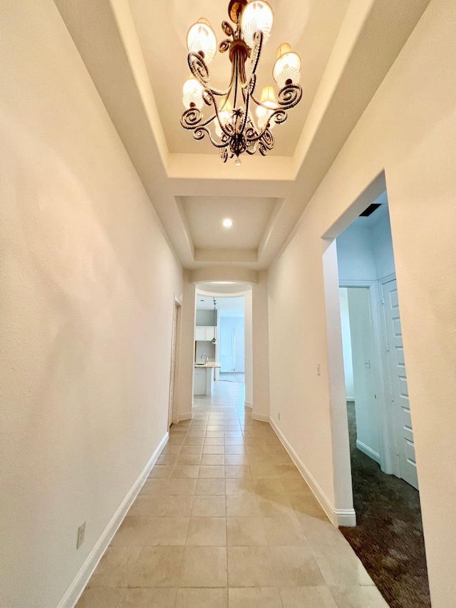 1610 Nacogdoches Valley Dr, League City, TX 77573 - corridor featuring a tray ceiling, an inviting chandelier, baseboards, and light tile patterned floors