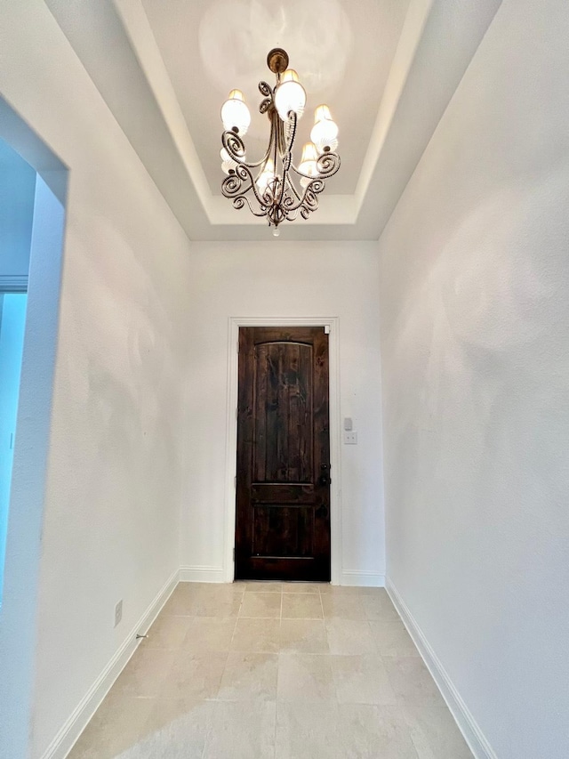 1610 Nacogdoches Valley Dr, League City, TX 77573 - entrance foyer with a tray ceiling, baseboards, a chandelier, and light tile patterned flooring