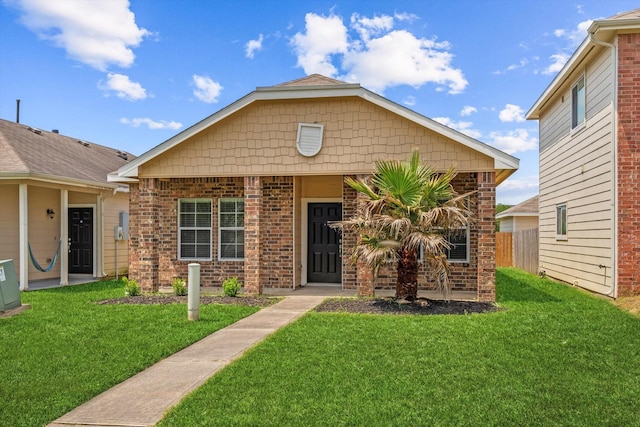 view of front facade featuring a front yard and brick siding