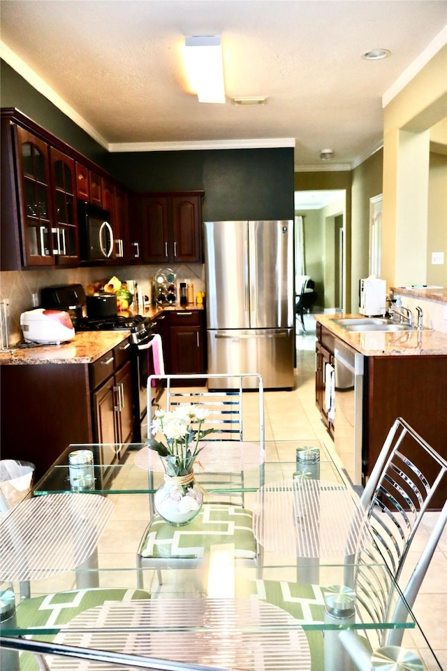9307 Langley Springs Dr, Houston, TX 77095 - kitchen with stainless steel appliances, crown molding, tasteful backsplash, glass insert cabinets, and a sink