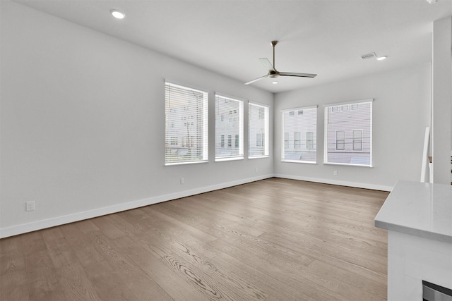 unfurnished living room featuring light wood-style floors, baseboards, a ceiling fan, and recessed lighting