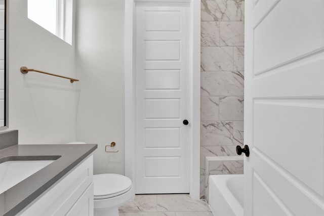 bathroom featuring toilet, tub / shower combination, marble finish floor, and vanity